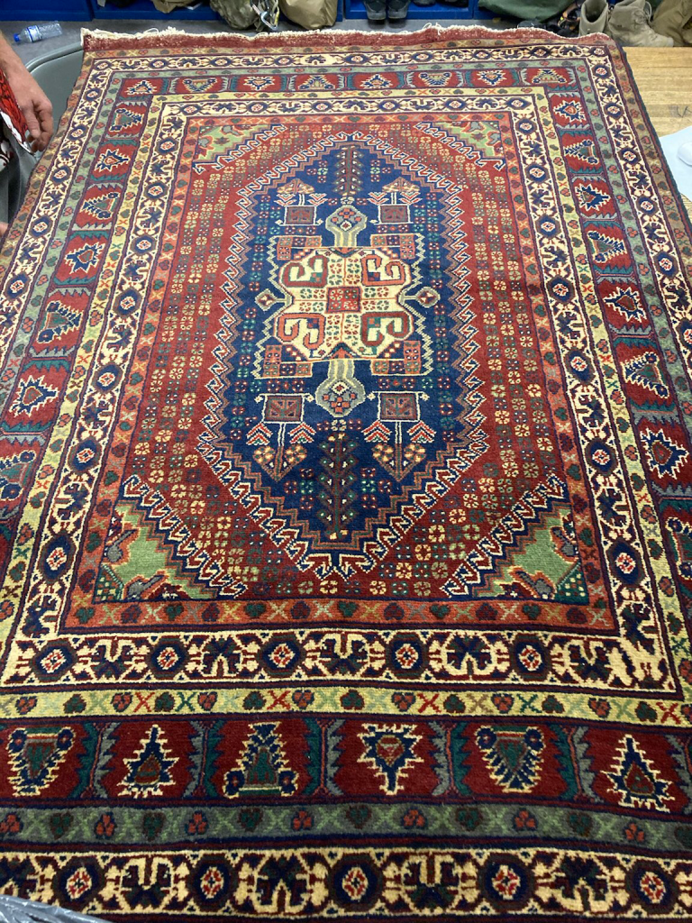 Stolen Persian hand knotted rug from Afghanistan with red, blue, green, and yellow pattern